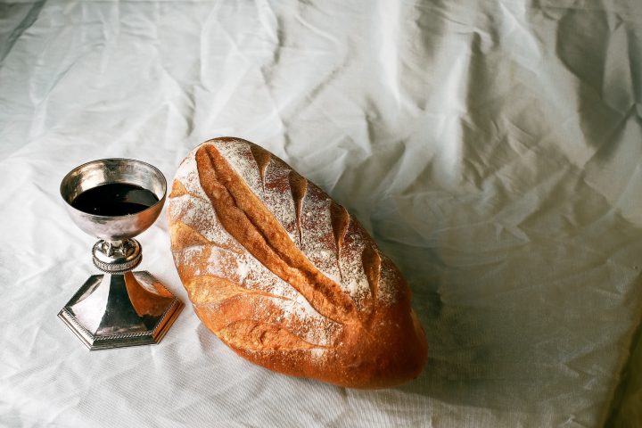 bread on white textile beside clear glass mug