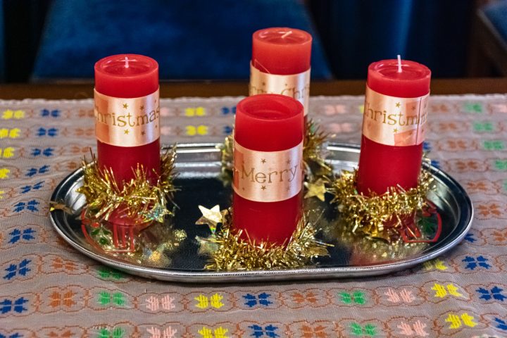 three red candles sitting on a silver tray